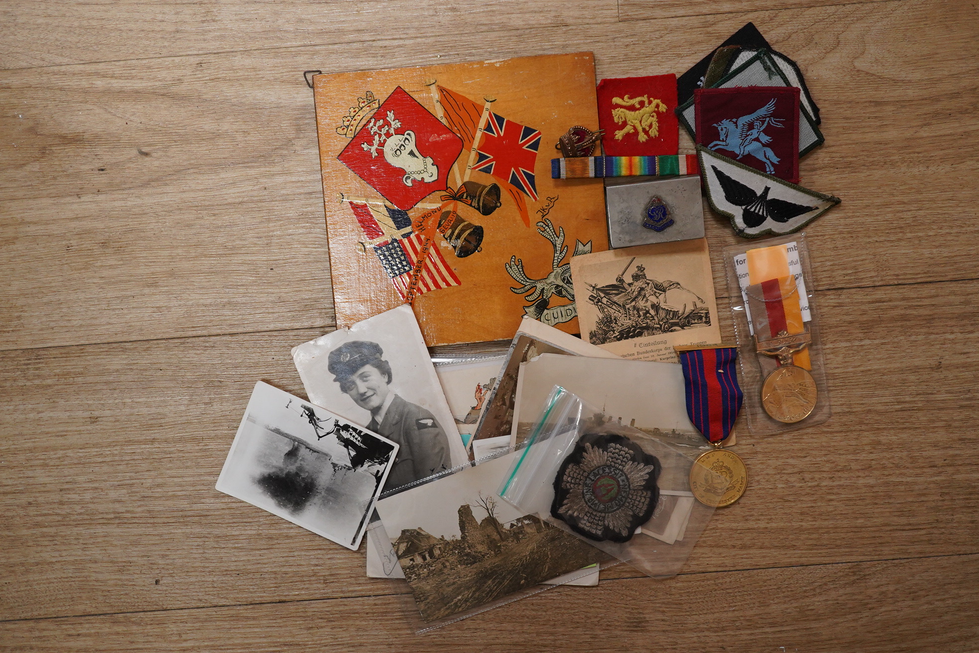 A quantity of various military ephemera to include a Coldstream guards matchbox holder, a death plaque and another 19th century glass plaque, buttons, badges, National Registration Identity Card, various photos and lette